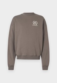 Brun genser laget av bomull, med rund hals, lange ermer og en liten brodert logo på brystet.