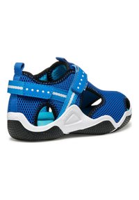 Blå nät-sandaler med svarta accenter, med två justerbara remmar, ett vadderat inre och en vit gummisula med mönstrad textur.