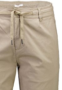 Lichtbeige katoenen shorts met een tailleband met trekkoord, met een gladde textuur en minimale stikseldetails.