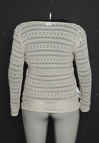 Blouse en dentelle à manches longues couleur crème avec motifs floraux, présentée sur un mannequin sur fond noir, vue de dos.