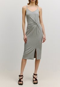 Graues, ärmelloses Kleid mit einem verdrehten Vorderteil und einem hohen Schlitz bis zum Oberschenkel. Hergestellt aus weichem Stoff mit einer figurbetonten Silhouette.