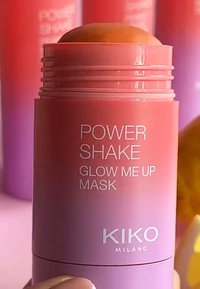 Maschera KIKO Milano Power Shake Glow Me Up, una stick ombreggiata in rosa con una parte superiore arrotondata e un'etichetta di testo bianca; presenta un design cilindrico liscio.