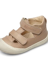 Beige kožené sandály s dvojitými suchými zipy, zaoblenou špičkou a texturovanou gumovou podrážkou. Obsahují vyřezávaný design a prošité detaily.