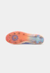 Suela de un zapato deportivo con clavos en colores naranja, azul e iridiscente, con clavos circulares y un patrón en espiral cerca de la punta.