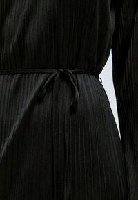 Schwarzer, plissierter Kleiderstoff mit einer glatten, glänzenden Textur, mit einer gebundenen Taille und subtilen vertikalen Linien für zusätzliche Details.