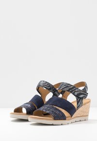 Námořnické wedges sandály s kombinací hladké semišové kůže a vzorovaného textilu, s kříženými pásky a tkanou texturou na podpatku.