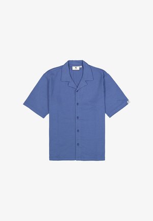 Camisa azul de manga corta con botones, cuello tipo campamento y una pequeña etiqueta con logo en la manga izquierda.