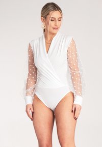 Biały bodysuit z przezroczystymi bufkami w kropki, fasonu kopertowego i dopasowanym dołem. Gładka tekstura z kontrastującymi satynowymi mankietami.