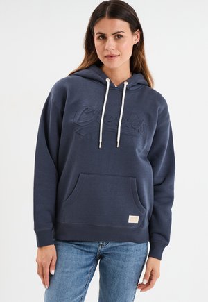 Sudadera con capucha azul marino, con un logo texturizado, bolsillo frontal y cordones crema. Tela suave con puños y dobladillo de canalé.