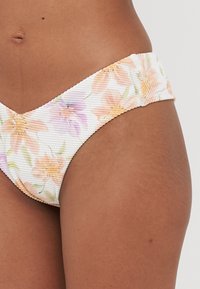 Floral bikini bottom featuring a ribbed texture, predominantly white with pastel orange and purple flowers and a soft, gathered waistband.