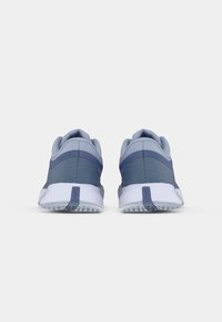 Sapatilhas desportivas com um upper entrelaçado em azul e cinza, com calcanhar reforçado e sola branca apresentando padrões de borracha texturizada para tração.