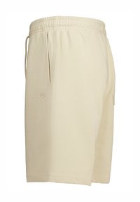 Beige, polvimittaiset shortsit pehmeästä kankaasta, joissa on joustava vyötärönyöri ja sivutaskut. Kirjailtu logoyksityiskohta.