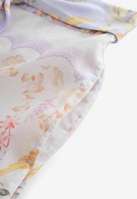 Licht stof met pastelbloemenpatroon in tinten roze, geel en paars, met fijne stiksels en een gladde textuur.