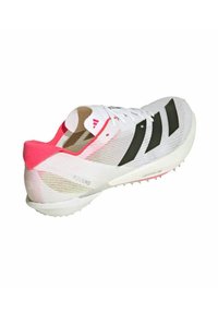 Witte sportschoen met zwarte strepen, roze accenten en een bovenwerk van gestructureerd mesh. Beschikt over een lichtgewicht zool met spikpatroon voor grip.
