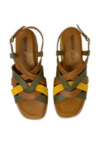 Sandali in pelle marrone con accenti in suede verde e giallo; presentano fasce incrociate e una chiusura con fibbia. Soletta imbottita e suola piatta.
