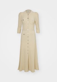 Stickad midi-klänning i ljusbeige, med två bröstfickor, knäppning fram och trekvartslånga ärmar med subtil texturdetalj genom hela plagget.