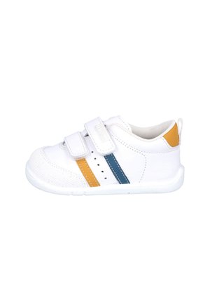 Zapato blanco para niño pequeño con rayas laterales amarillas y azules, dos tiras de velcro y una lengüeta amarilla en el talón sobre un fondo blanco.