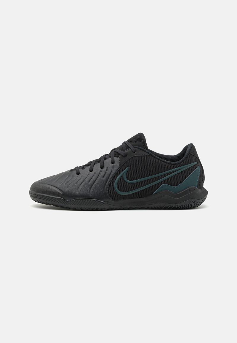 Melna sporta kurpe ar teksturētu sintētisko augšdaļu, sieta daļām, melnu šņoru un tumši zilā Nike zvana logotipu sānos. Gumijas zole.