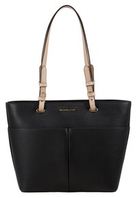 Mustapahkainen nahkatote bagi, jossa on kivetty pinta. Varustettu kahdella vaaleanruskealla olkahihnalla ja kultaisella logolla etupuolella. Kaksi ulkopuolta taskua.