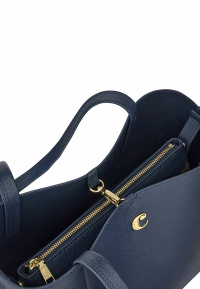 Temno modra usnjena torba za na roko z dvema ročajema, notranjim žepom z zadrgo z zlatim zadrgo in zlatim logotipom na sprednji zaponki.