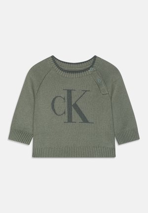 Maglione verde lavorato a maglia con maniche corte, caratterizzato da un grande logo "CK" grigio scuro sul davanti e dettagli a bottone vicino al colletto.