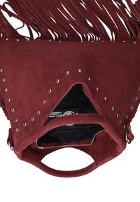 Bordeaux suède handtas met zilveren studs, franjes, ronde handvaten en een gedeeltelijk open rits die een zwarte stoffen binnenkant onthult.