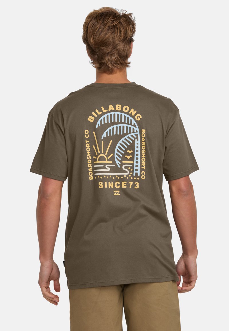 Olive green t-shirt featuring a multicolor graphic of palm trees and sun on the back, with text reading "BILLABONG BOARDSHORT CO SINCE 73."