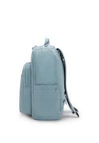 Mochila de tela azul claro con una textura suave, dos compartimentos con cremallera, un bolsillo lateral y correas ajustables. Vista lateral mostrada.