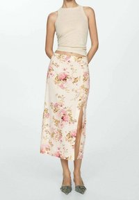 Květinová midi sukně v krémové barvě, se vzorem růžových růží a zelených listů, s bočním rozparkem a plochým pasem, v kombinaci s lehkým béžovým topem.