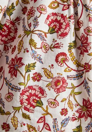 Baumwollstoff mit einem floralen Muster, das rote, pinke, grüne und blaue Elemente auf einem weißen Hintergrund zeigt; ausgefallene Details und weiche Textur.