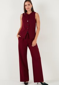 Vesta eleganta bordeaux cu guler rotund, închidere cu nasturi și buzunare laterale, asortată cu pantaloni largi din același material și culoare.