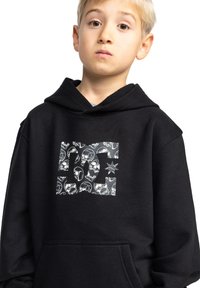 Zwarte hoodie met een voorkant kangaroo zak, voorzien van een grafisch ontwerp van schedels en sterren in grijs op de borst. Gemaakt van een zacht katoenmix materiaal.