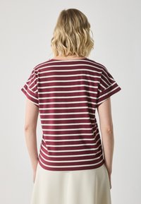 Short-sleeve shirt with deep burgundy and cream horizontal stripes, featuring a round neckline and soft, lightweight fabric.