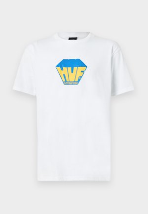 Camiseta de algodón blanca con un logo hexagonal azul y amarillo que dice "HUF INTERNATIONAL" en letras negritas en la parte frontal.