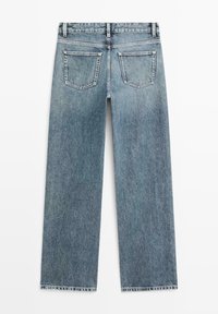 Lichtblauwe denim spijkerbroek met rechte pijpen, gezien van achteren, met twee achterzakken en riemlussen.