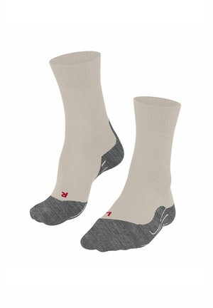 Beige enkelsokken met een versterkte teen en hiel in donkergrijs. Rood logo op de zool. Soepele textuur en een elastische boord voor comfort.