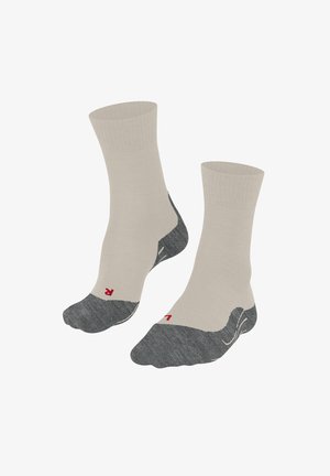 Beige enkelsokken met een versterkte teen en hiel in donkergrijs. Rood logo op de zool. Soepele textuur en een elastische boord voor comfort.
