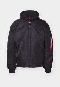 Black bomber jacket with a detachable hood, zip closure, ribbed cuffs, and side pockets. Features a red tag on the sleeve for detailing.