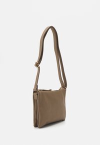 Tan schoudertas met een gladde textuur, ritssluiting, verstelbare strap en een minimalistisch ontwerp met subtiele stikdetails.