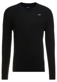 Pull noir à manches longues en V, fabriqué en matériau doux, avec un petit logo rouge sur la poitrine gauche et des poignets et un ourlet côtelés.