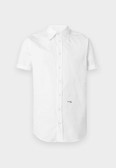 Chemise blanche à manches courtes avec col et petit texte de logo noir sur le bas à droite à l'avant.
