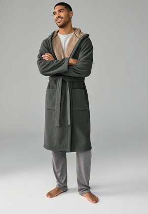 Grau-fleece Robe mit einem strukturierten Stoff und einer beige gefütterten Kapuze, ausgestattet mit zwei Fronttaschen und einem passenden grauen Gürtel.