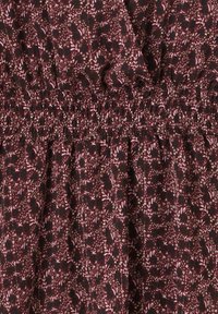 Robe en tissu bourgogne avec un motif floral rose, dotée d'une taille smockée, d'une texture légère et d'une silhouette fluide.