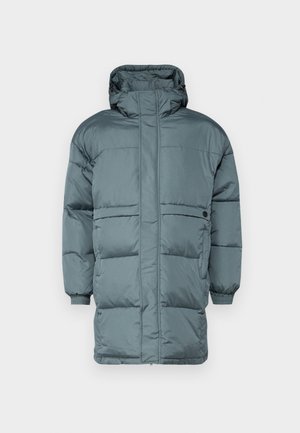 Lang dunfrakke i dæmpet teal. Fremstillet af kviltet materiale med hætte. Har elastiske manchetter og en frontlynlås. Minimalistisk design uden synlige logoer.