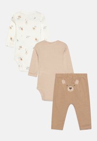 Ensemble pour bébé en trois pièces : un body blanc à motif animal, un body beige rayé et un pantalon marron avec un visage d'ours à l'arrière.