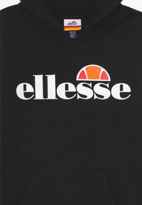 Sudadera con capucha negra con el logo "ellesse" en blanco y un diseño de semicírculo naranja encima del texto, etiqueta de talla visible dentro del cuello.