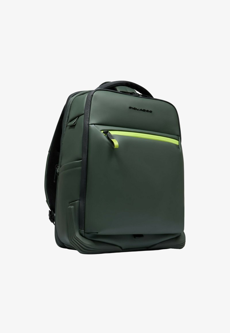 Groene rugzak gemaakt van glad materiaal, met een voorvak met rits in felgeel, een gevoerde achterkant en stevige handgrepen.