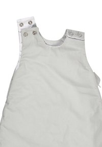 Graue Baumwoll-Latzhose mit rundem Halsausschnitt, Metall-Druckknöpfen an den Schulterträgern und einer Taschenapplikation an der Seite. Glatte Textur.