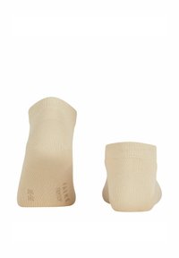 Beżowe skarpetki do kostek z gładkiego dzianiny, z prążkowanym ściągaczem i wzmocnionym palcem. Prosty design, bez wzorów czy akcentów.