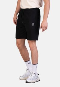 Schwarze Shorts aus einem Baumwollmix, mit einem elastischen Bund und seitlichen Taschen. Ein weißes Logo befindet sich auf der linken Vorderseite.